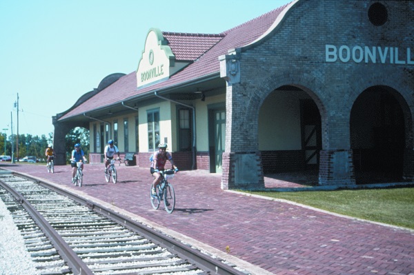 bicyclists riding next to railroad tracks in front of the Boonville Depot