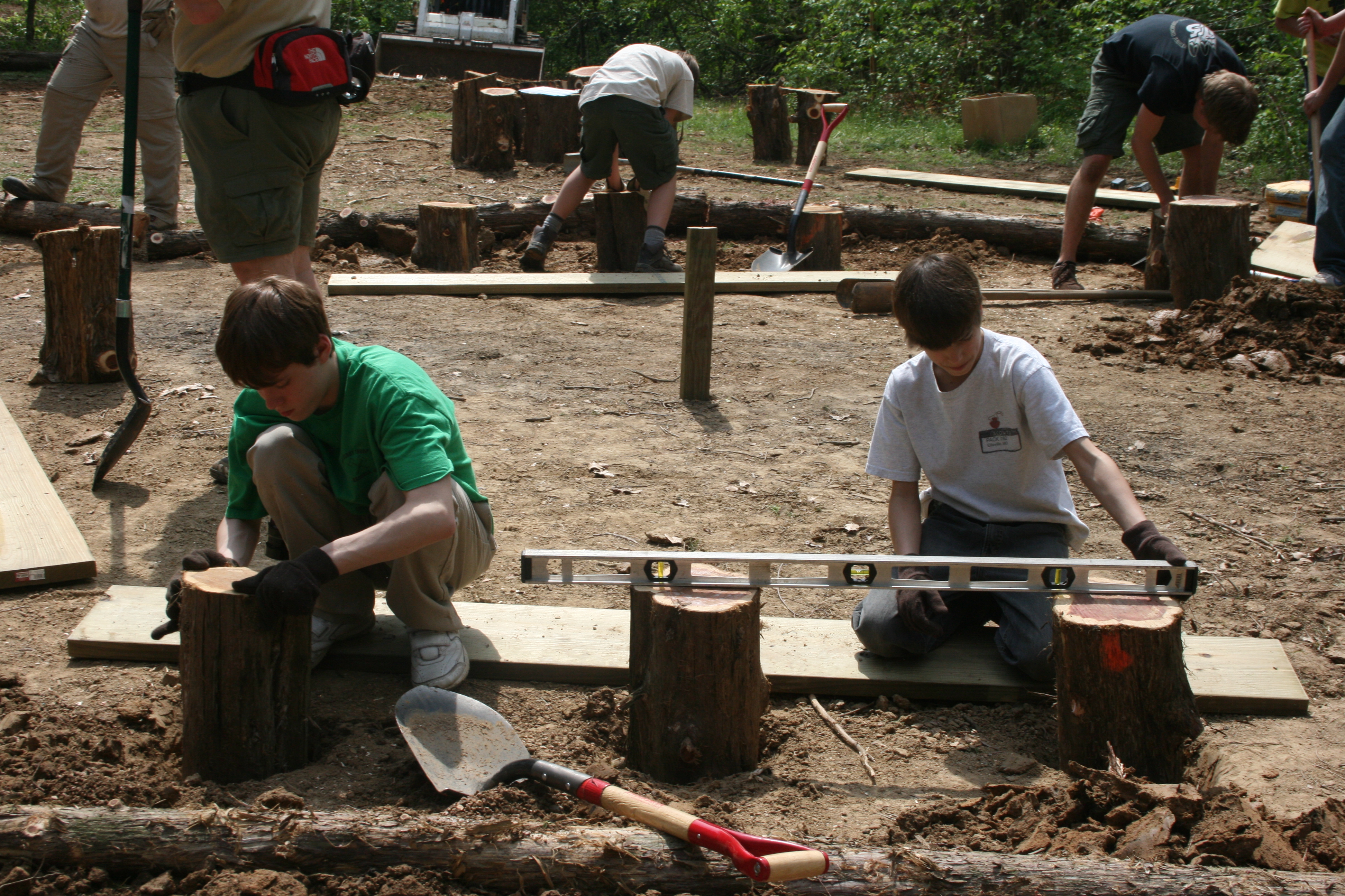 a group of Boy Scouts building benches 