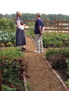 a tour guide with a lady walking through the site's gardens