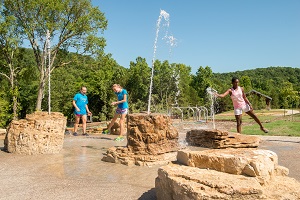 Kids playing in the water features of the playground at Echo Bluff State Park