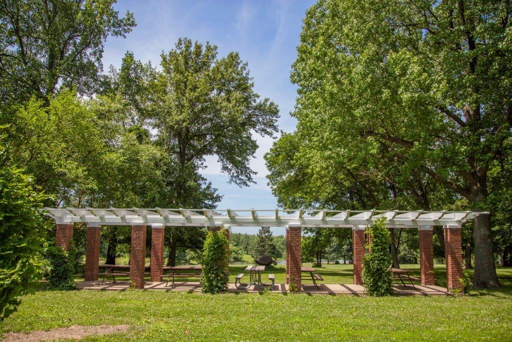 pergola with picnic tables under it