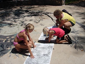 kids tracing concrete stamps onto paper