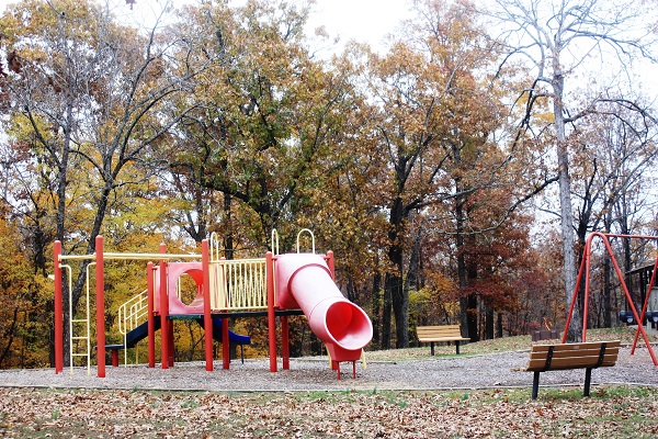 two benches next to the playground equipment with slides