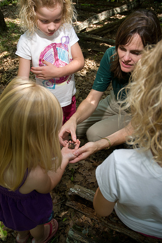 a naturalist showing a group of kids somethingin her hand