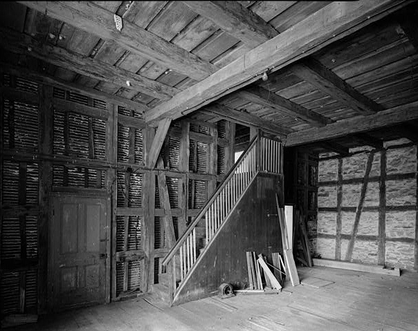 Black-and-white photo of main floor of Pelster House-Barn, featuring half-timbered construction