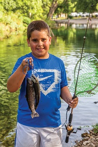 a kid holding up a fish he caught