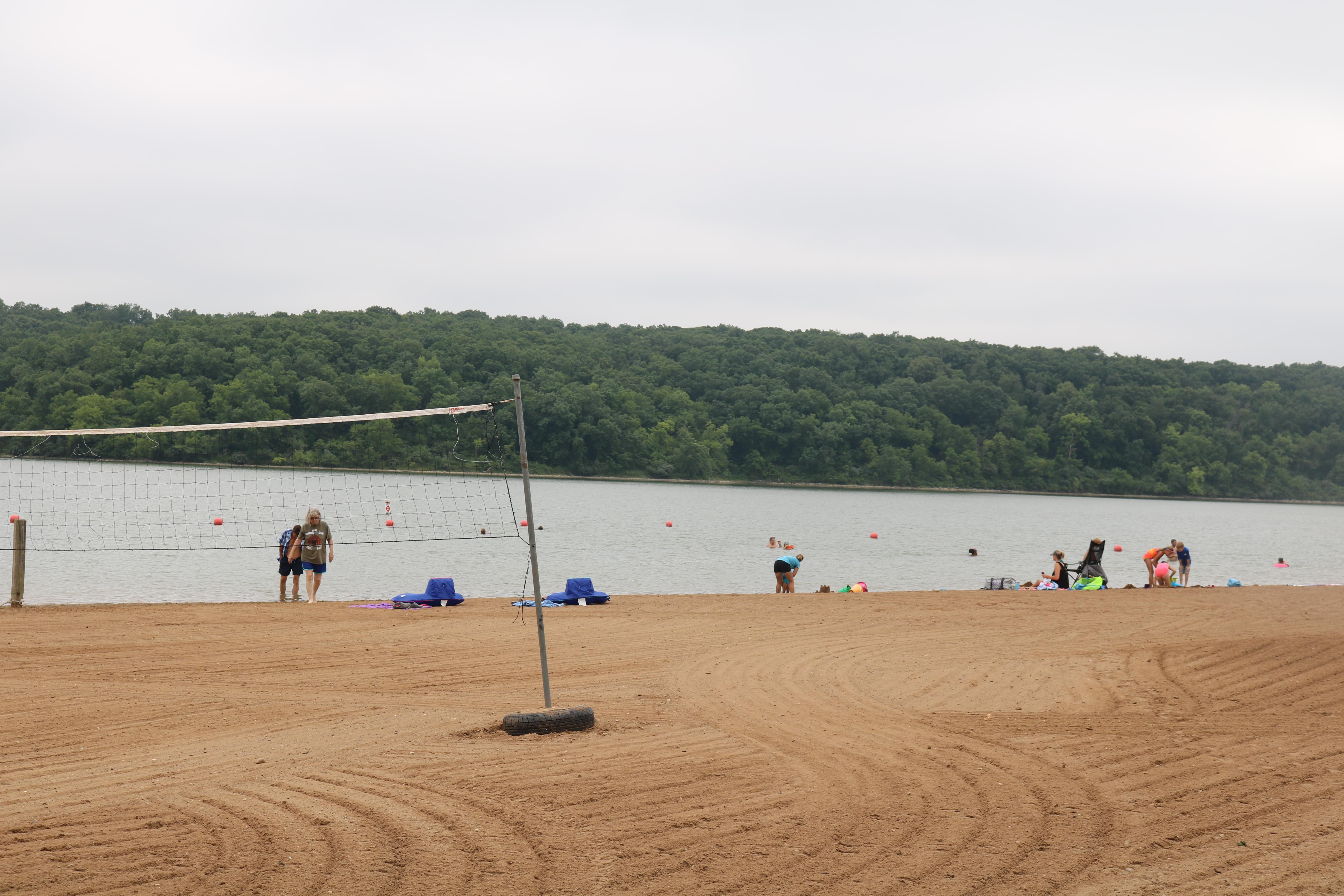 a volleyball net and people swimming in the lake