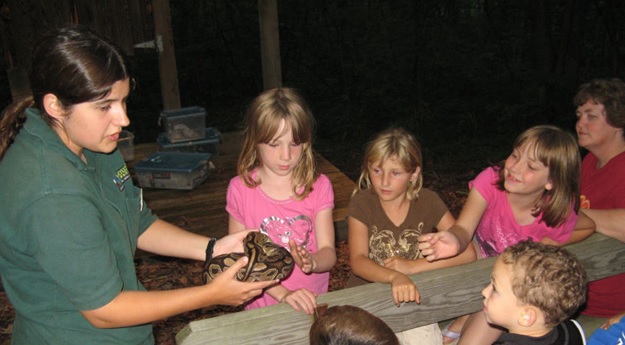 a naturalist shows some kids a snake