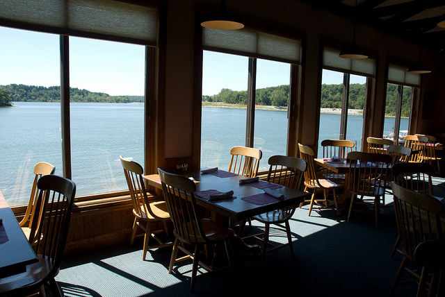 tables and chairs are lined up next to windows that overlook the lake