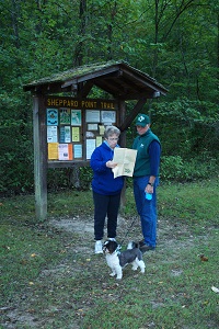 a couple with their dog looking at a park brochure