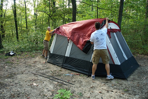 two men putting the fly on their tent