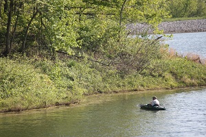 a man fishing out of a kayak on the lake