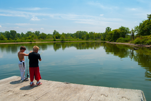 two boys fish from a dock