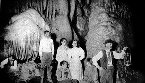 historic photo of people on a lantern-lit cave tour