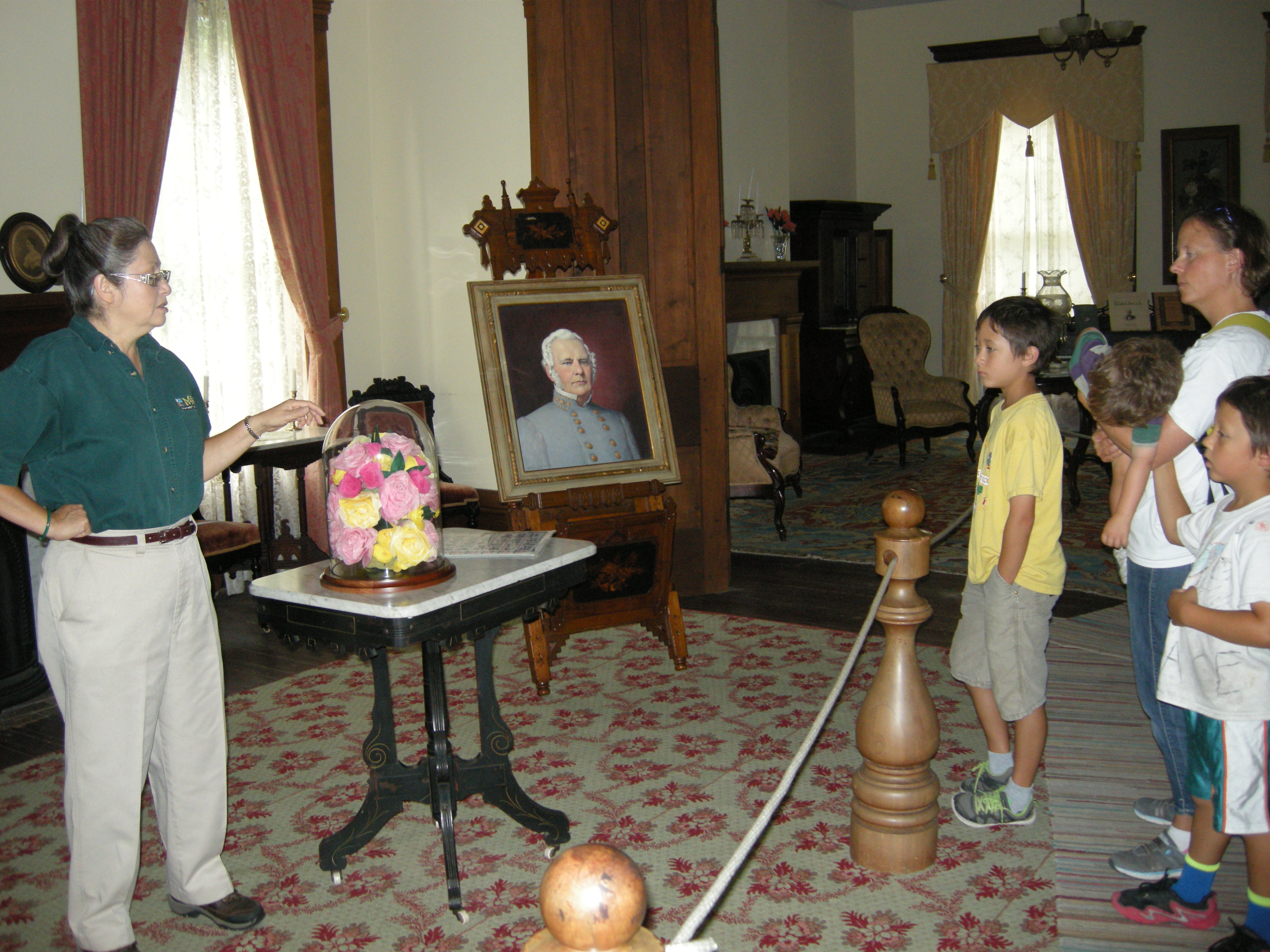 a family listens to the tour guide inside the Anderson House