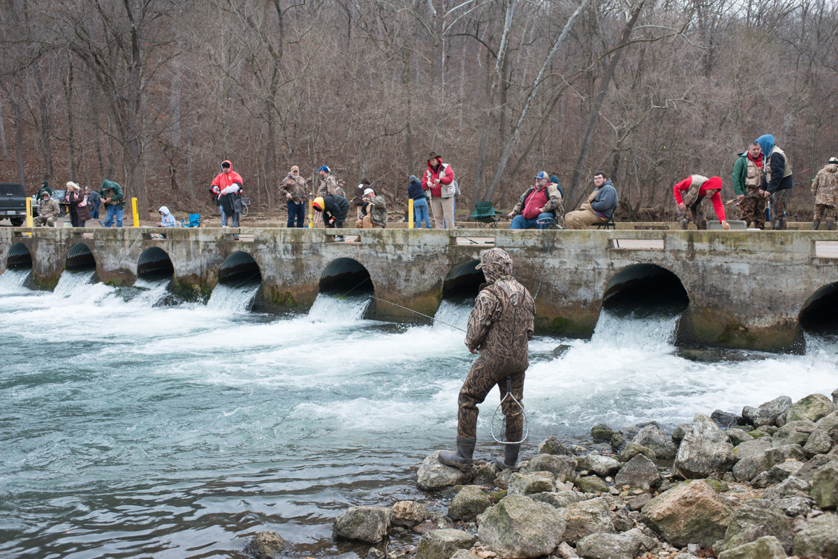 many people on an old stone bridge over a river