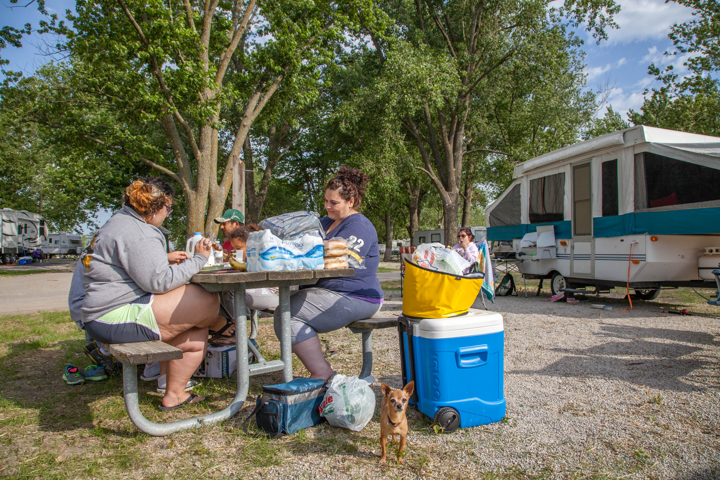 a family eating at a picnic table outside campers