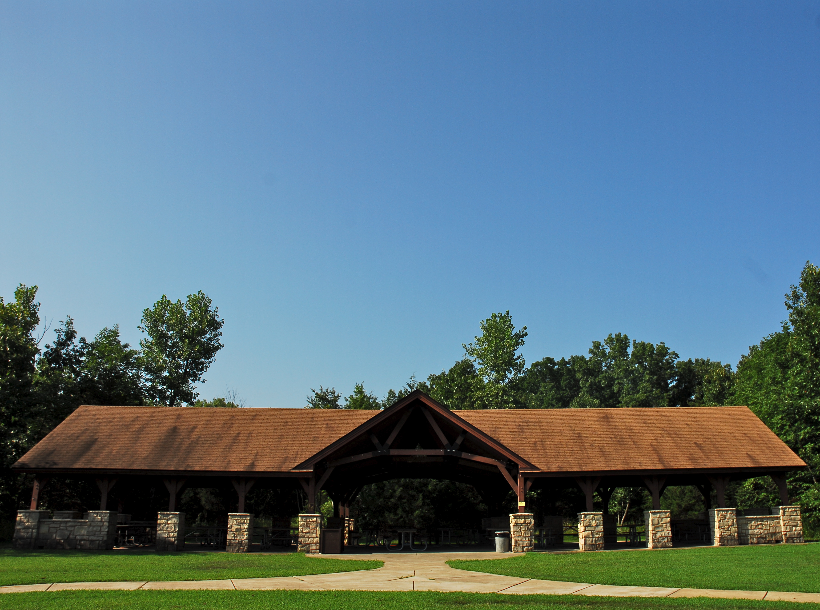 a large stone and wood picnic shelter