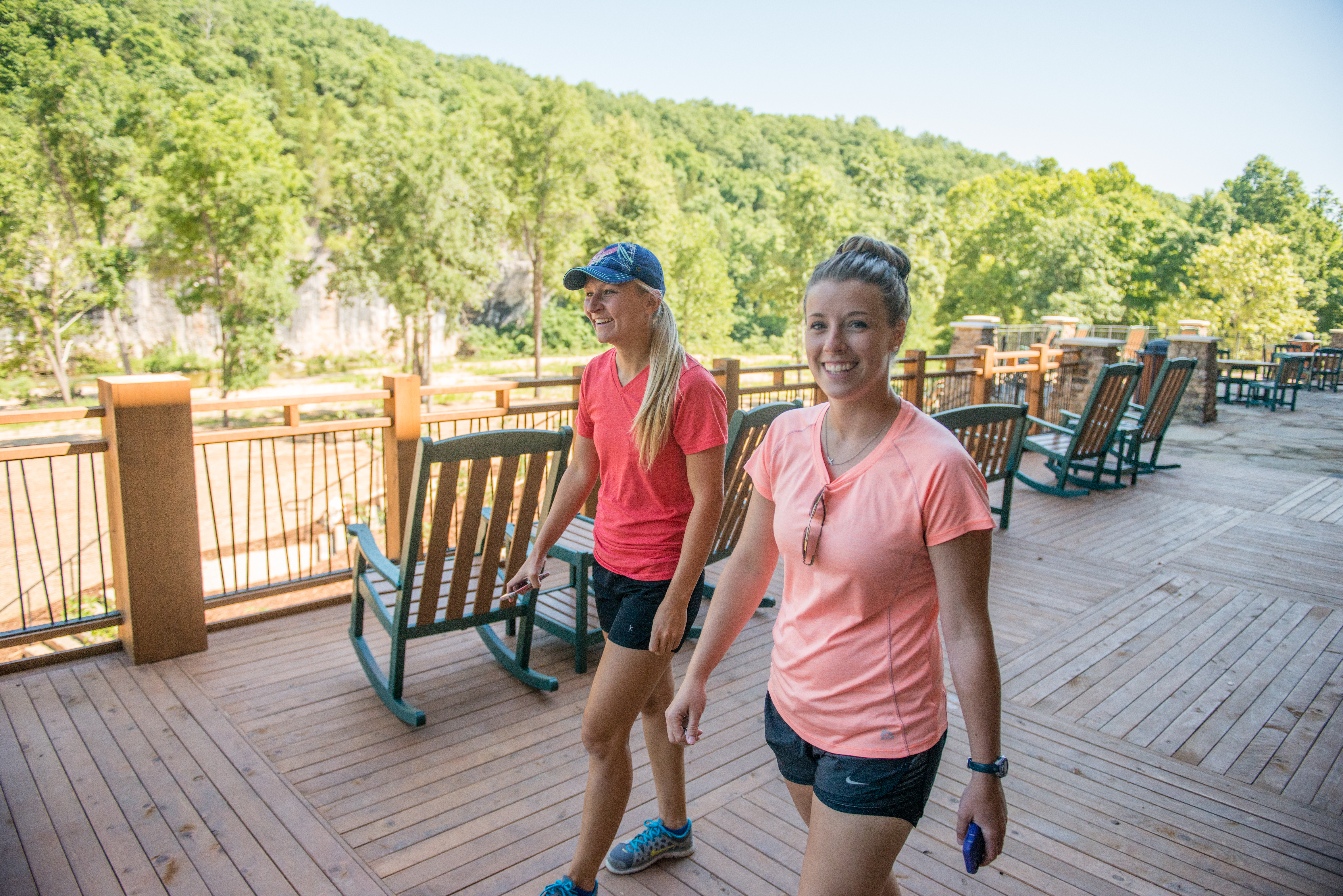 2 people walking down a wooden deck