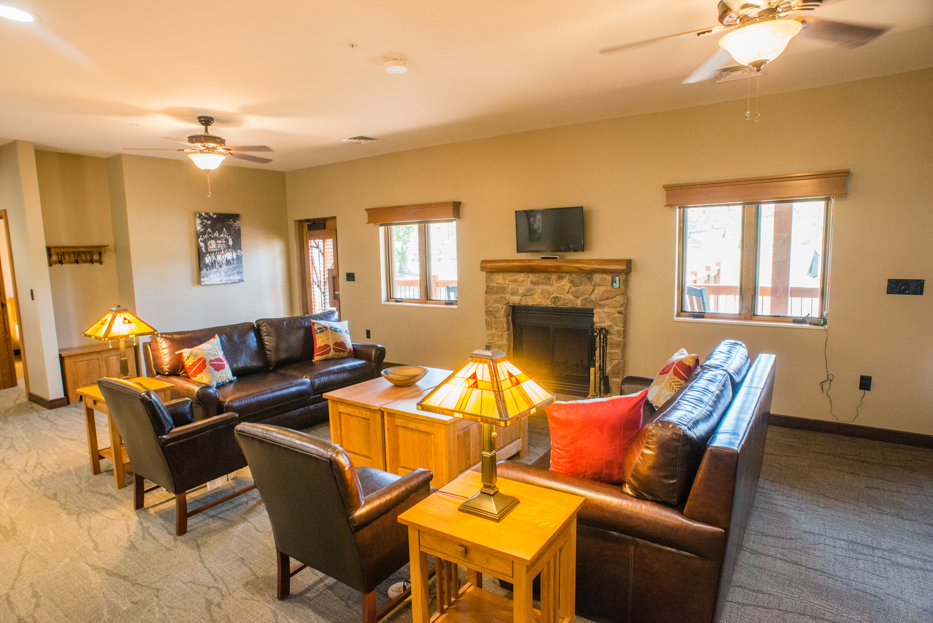 a lounge area with 2 couches, 2 chairs, and a TV