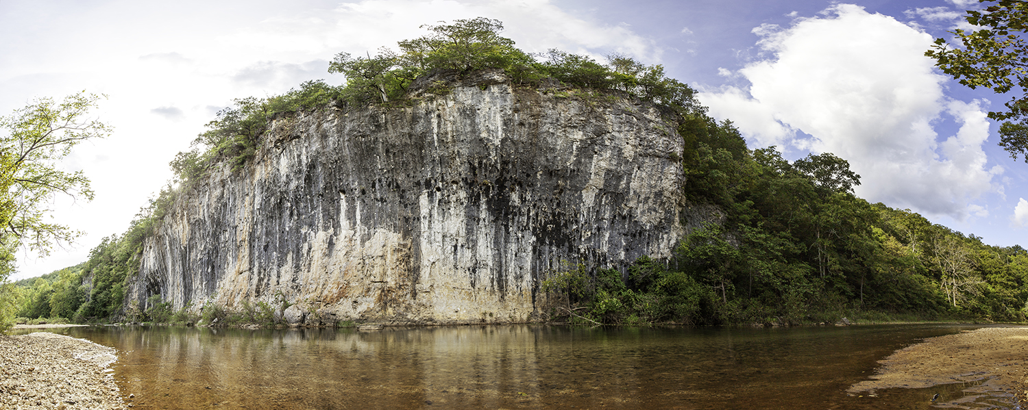 Panoramic image of a cliffside by a river