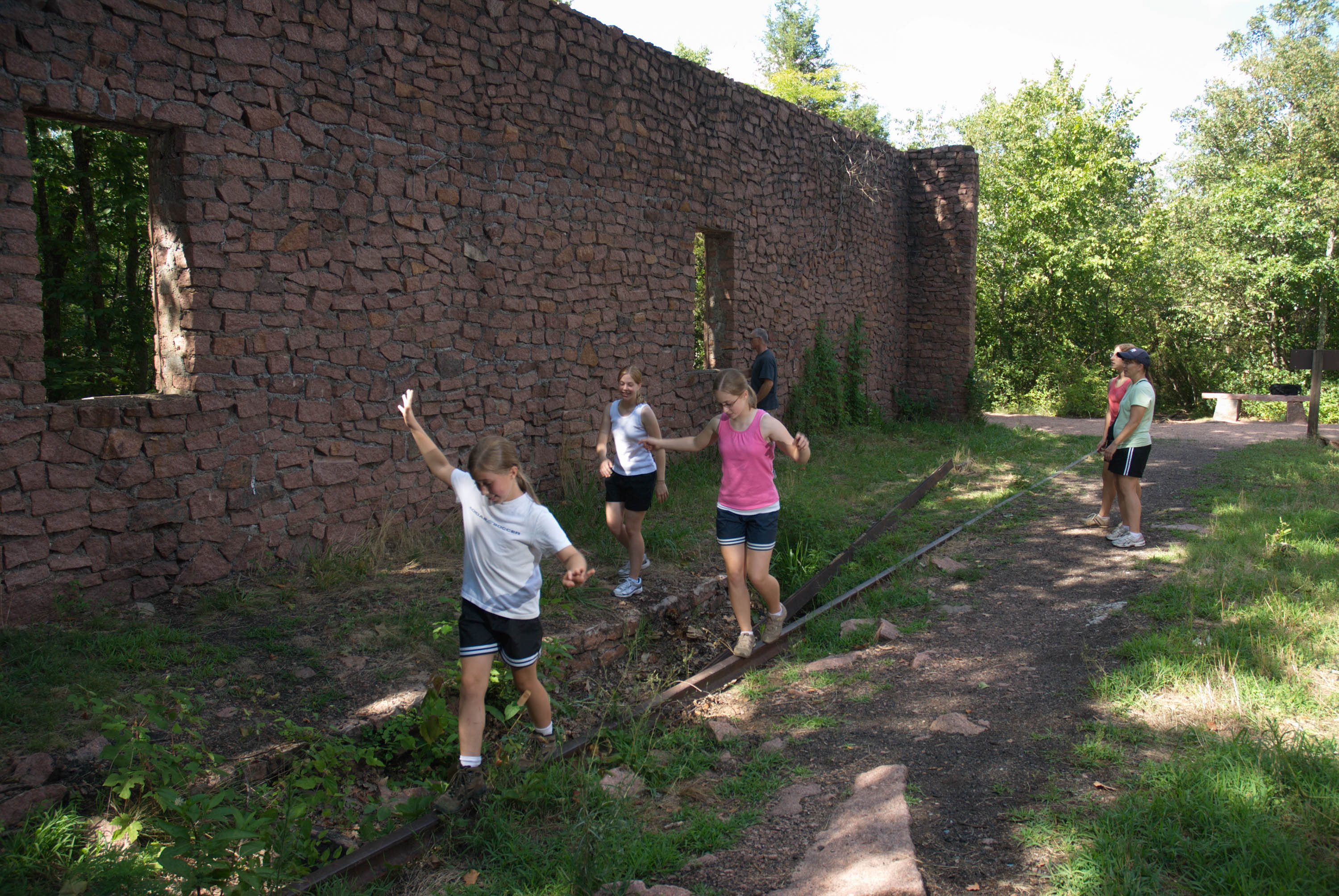 people playing by an old brick wall of a ruin