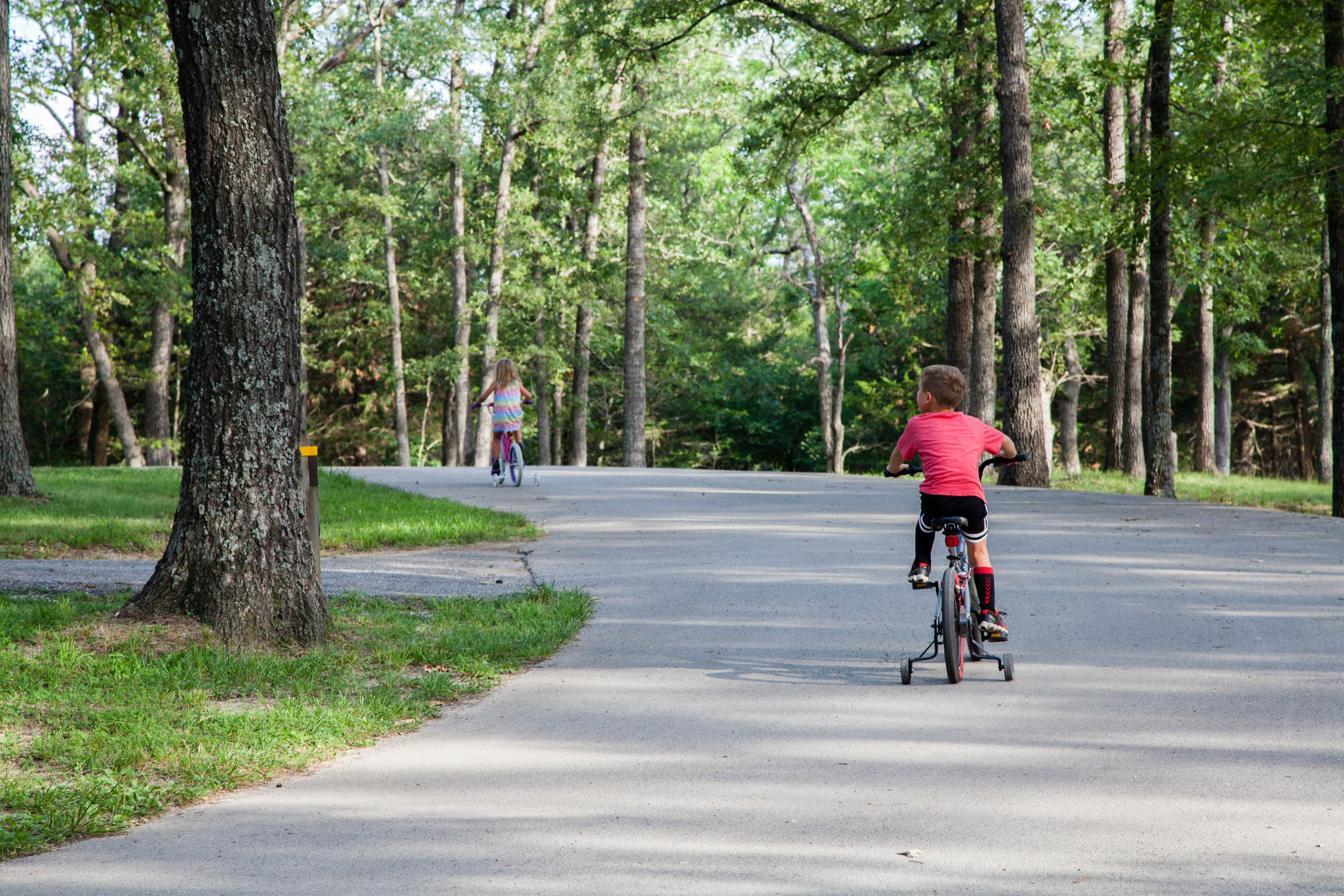 Kids biking down a paved path