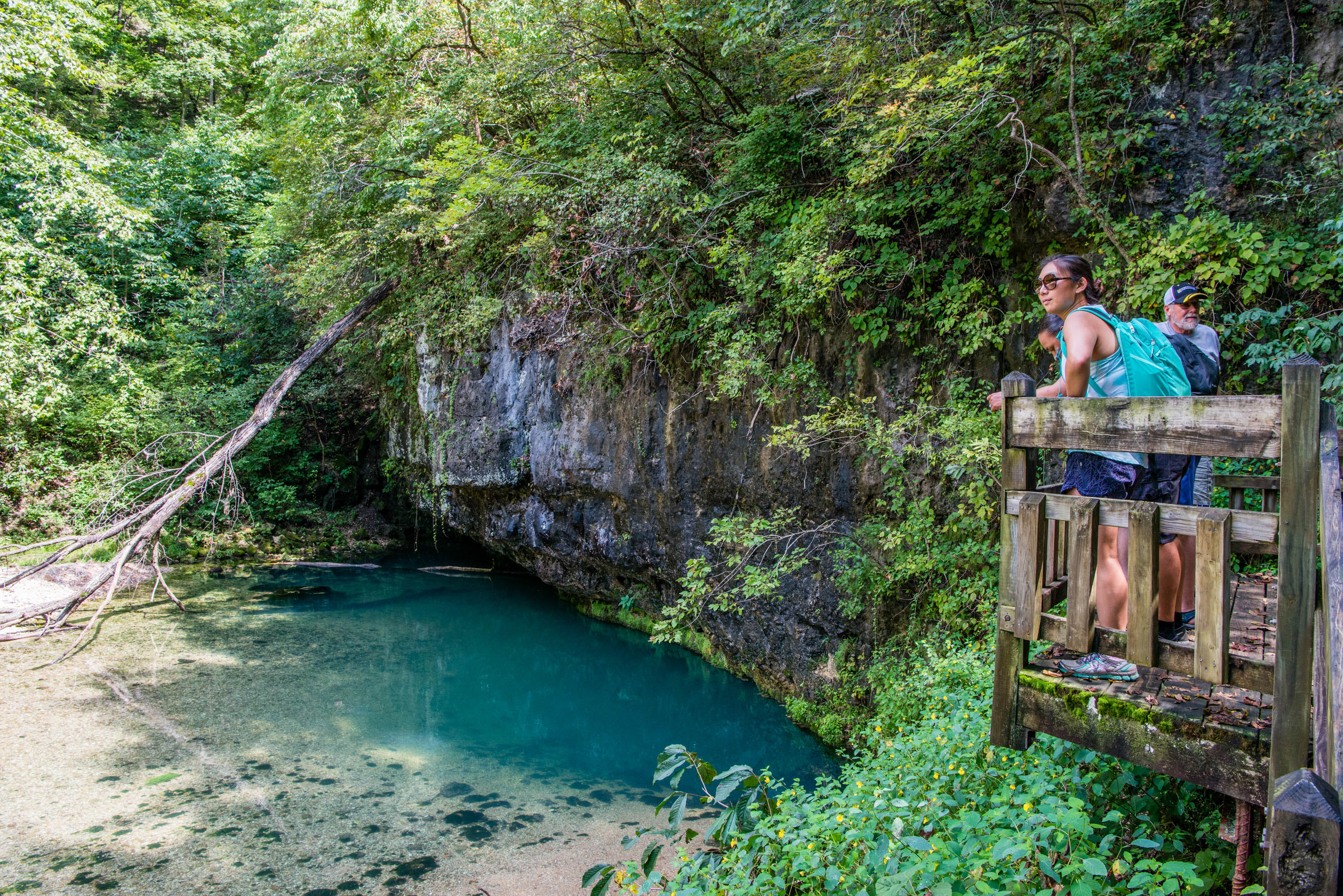 A group on a balcony over looking a underground lake in a cave