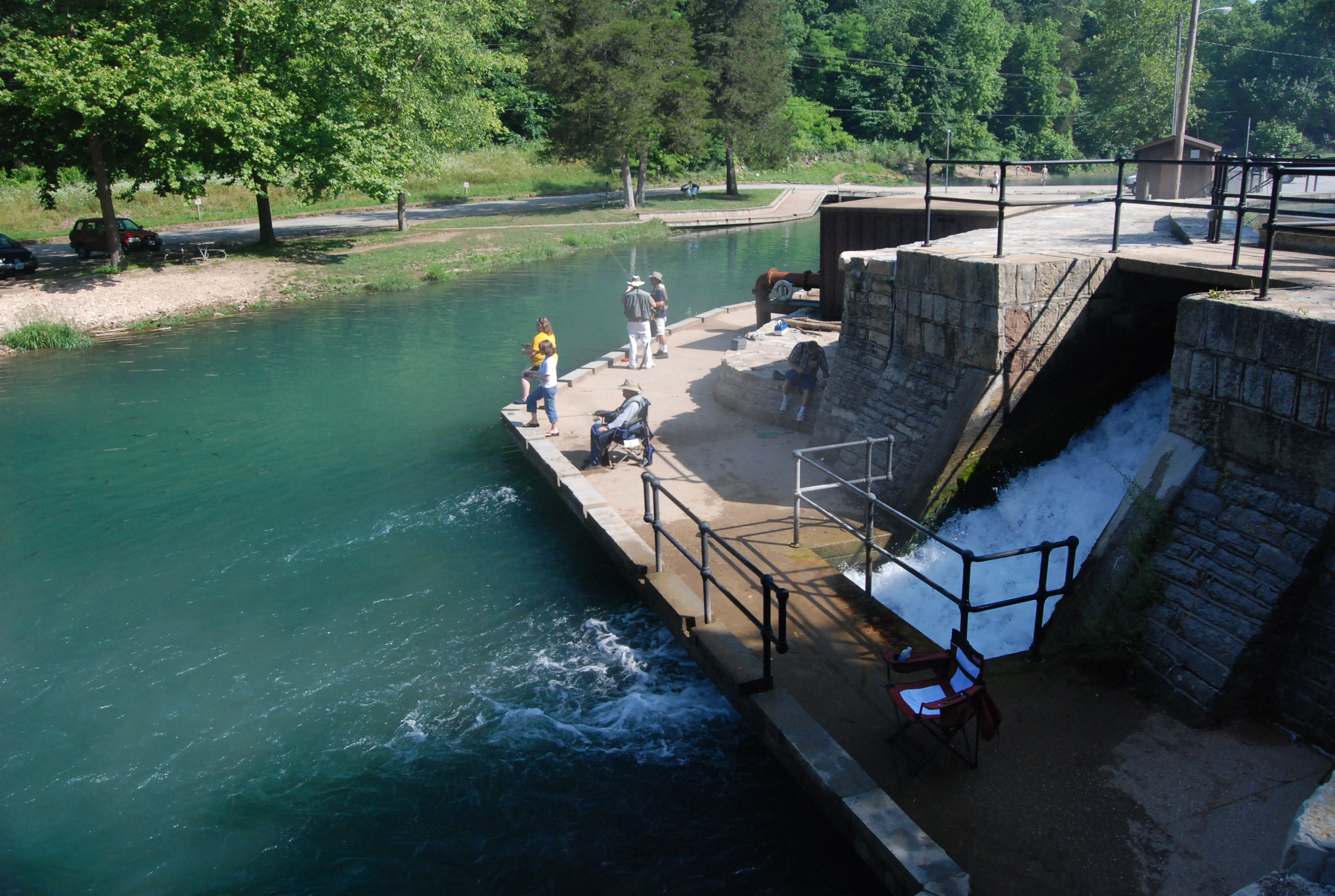 people fishing off a dock into a river