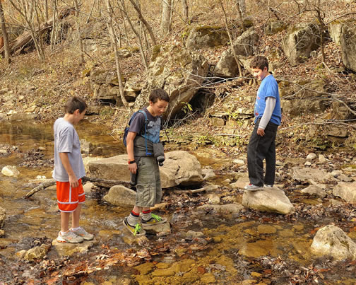Three kids standing in a creak
