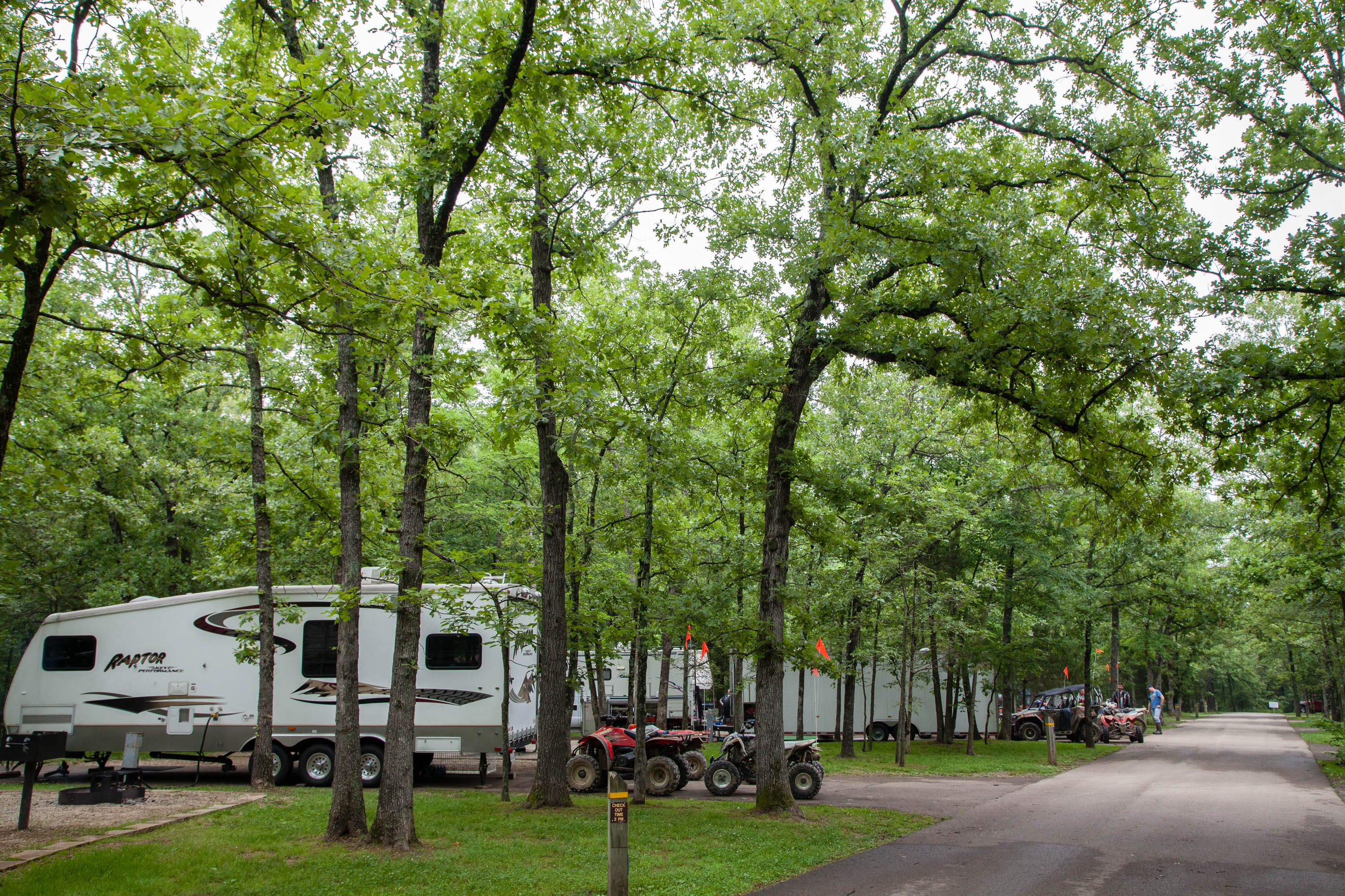Campers and four wheelers parked in the woods