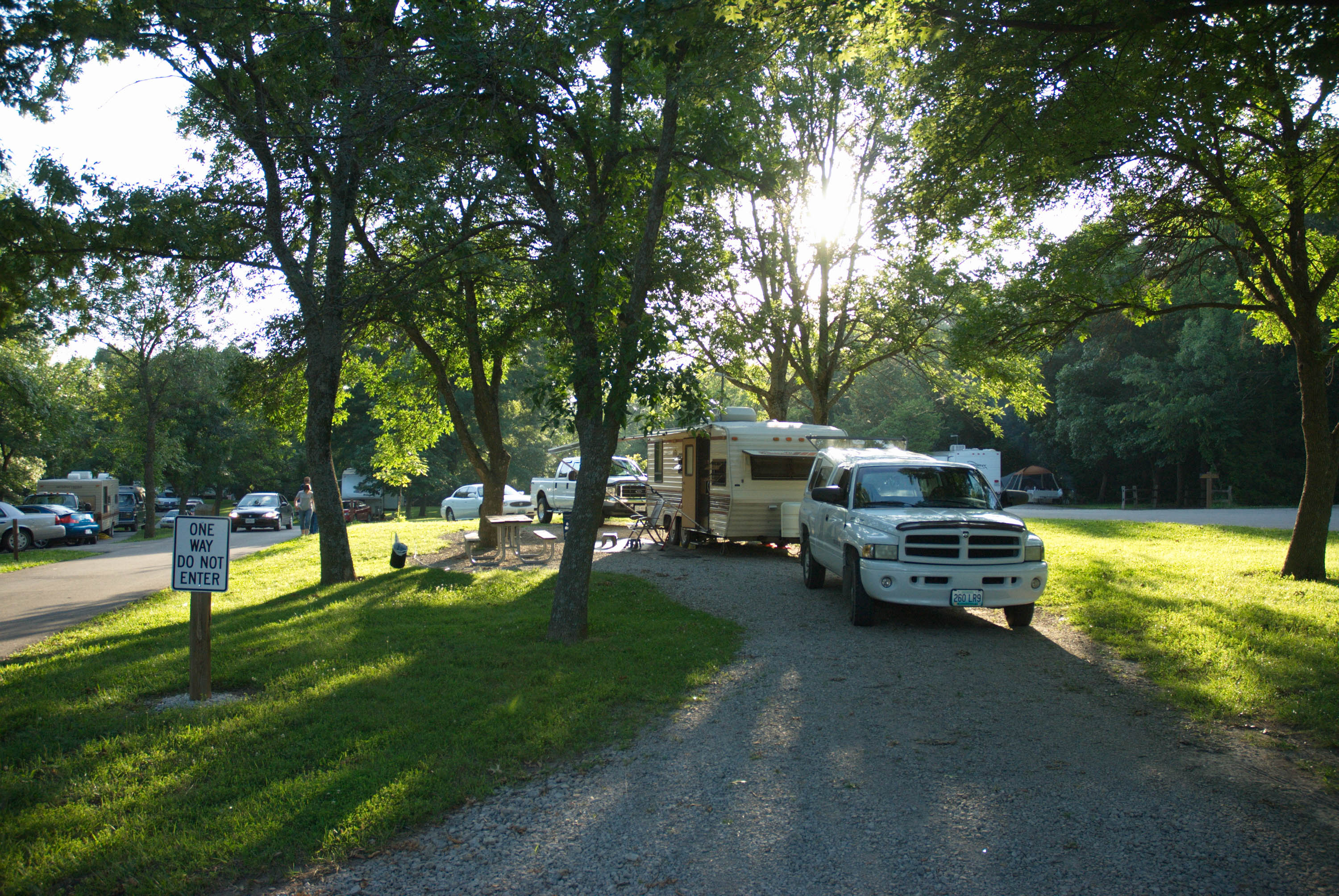A camper set up beside a picnic table