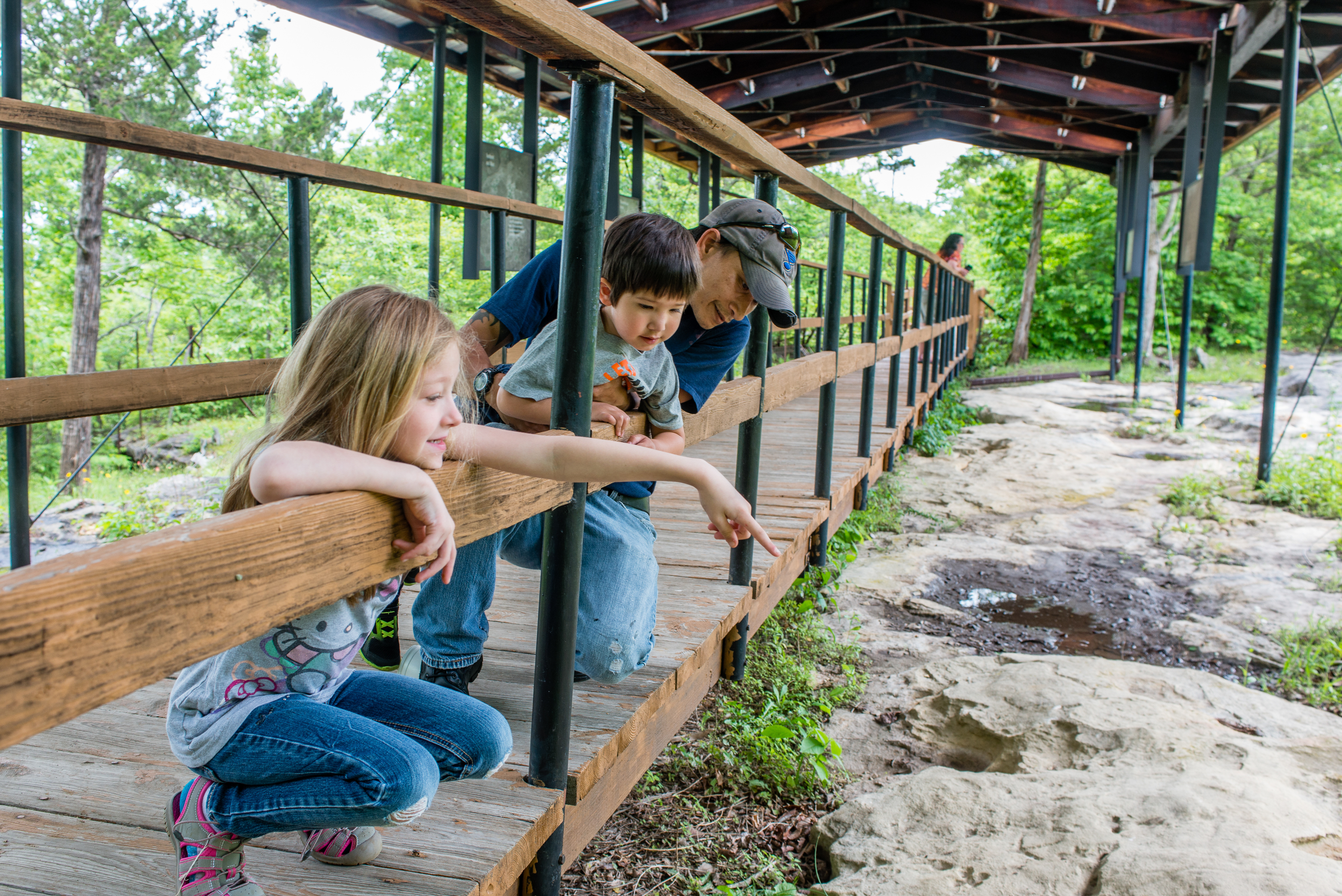 A family looking at something below the bridge