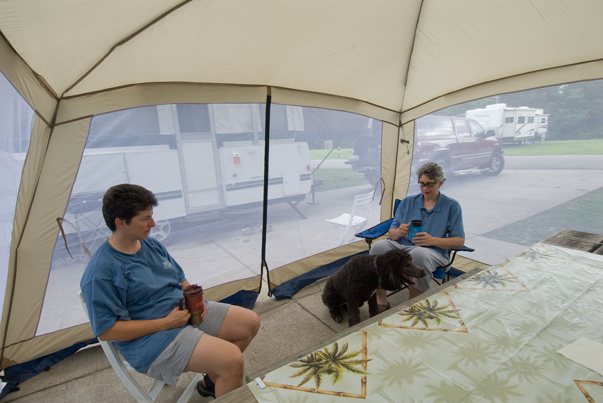 Two people in a tent with a dog