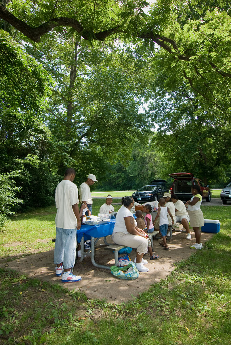 A family eating at a picnic table in the park