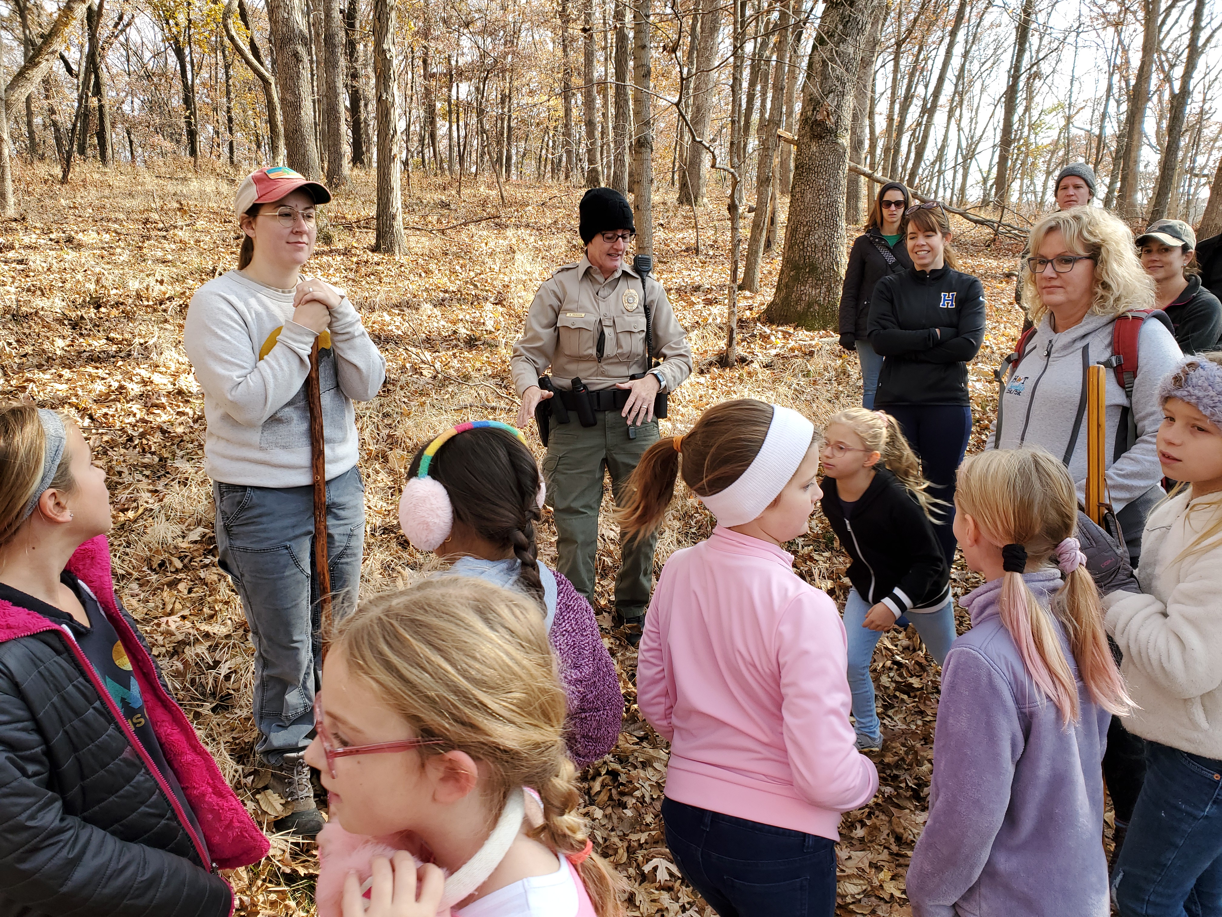 A group of kids on a school trip talking to a park ranger
