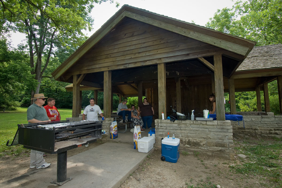 A group of people grilling at a picnic shelter