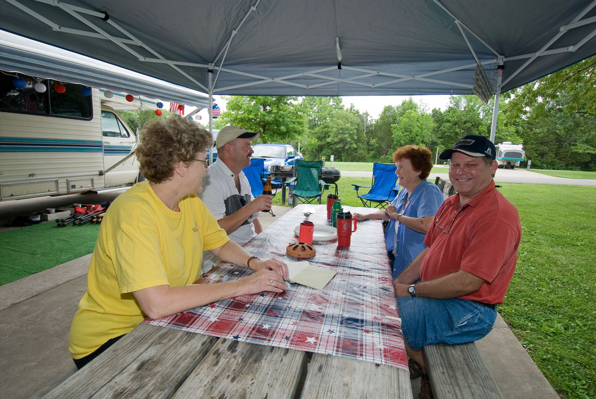 Four people talking at a picnic table