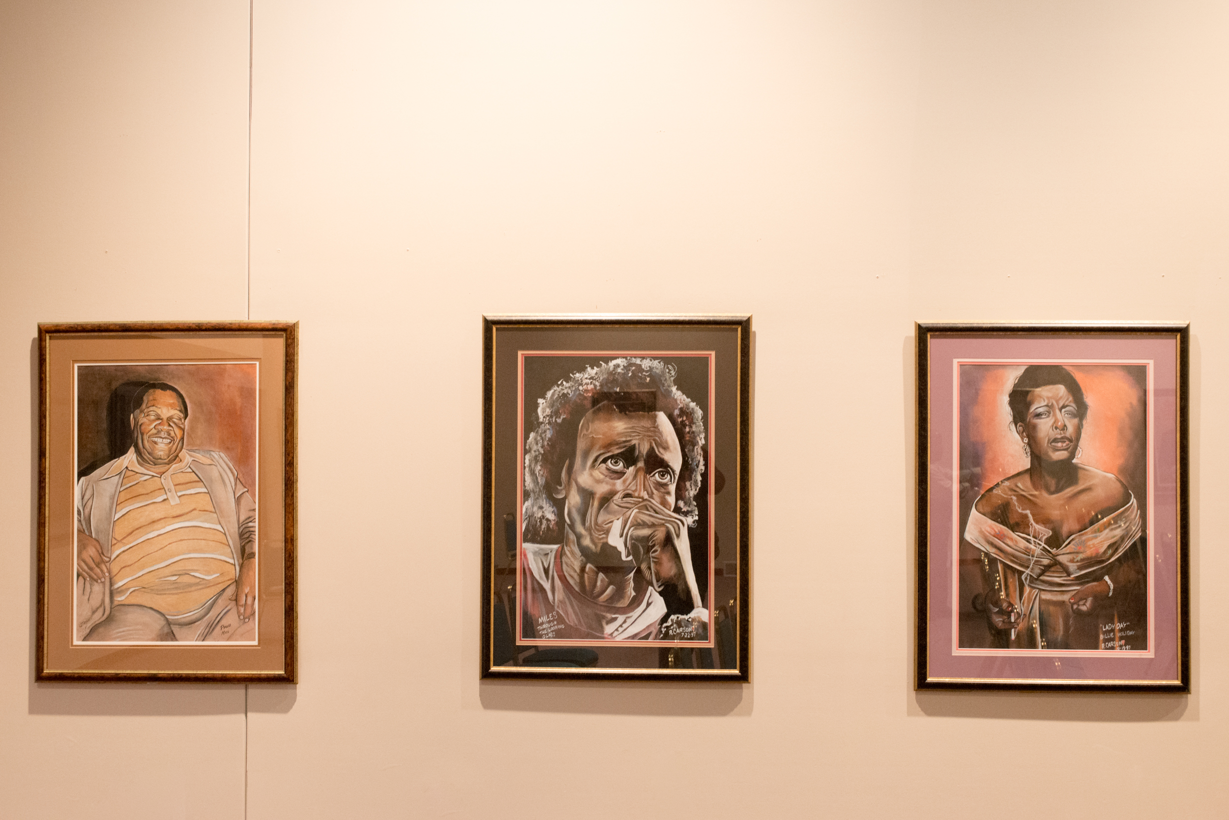 Three paintings of African American men and women on display at the Bruce R Watkins Heritage Center