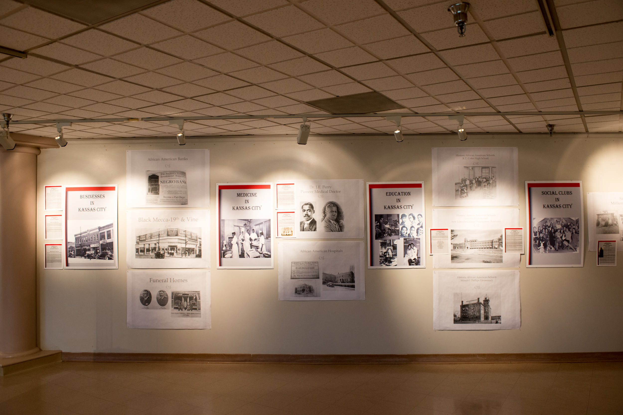 A wall with displays of the history of Businesses, Medicine, Education, and Social Clubs for African Americans in Kansas City