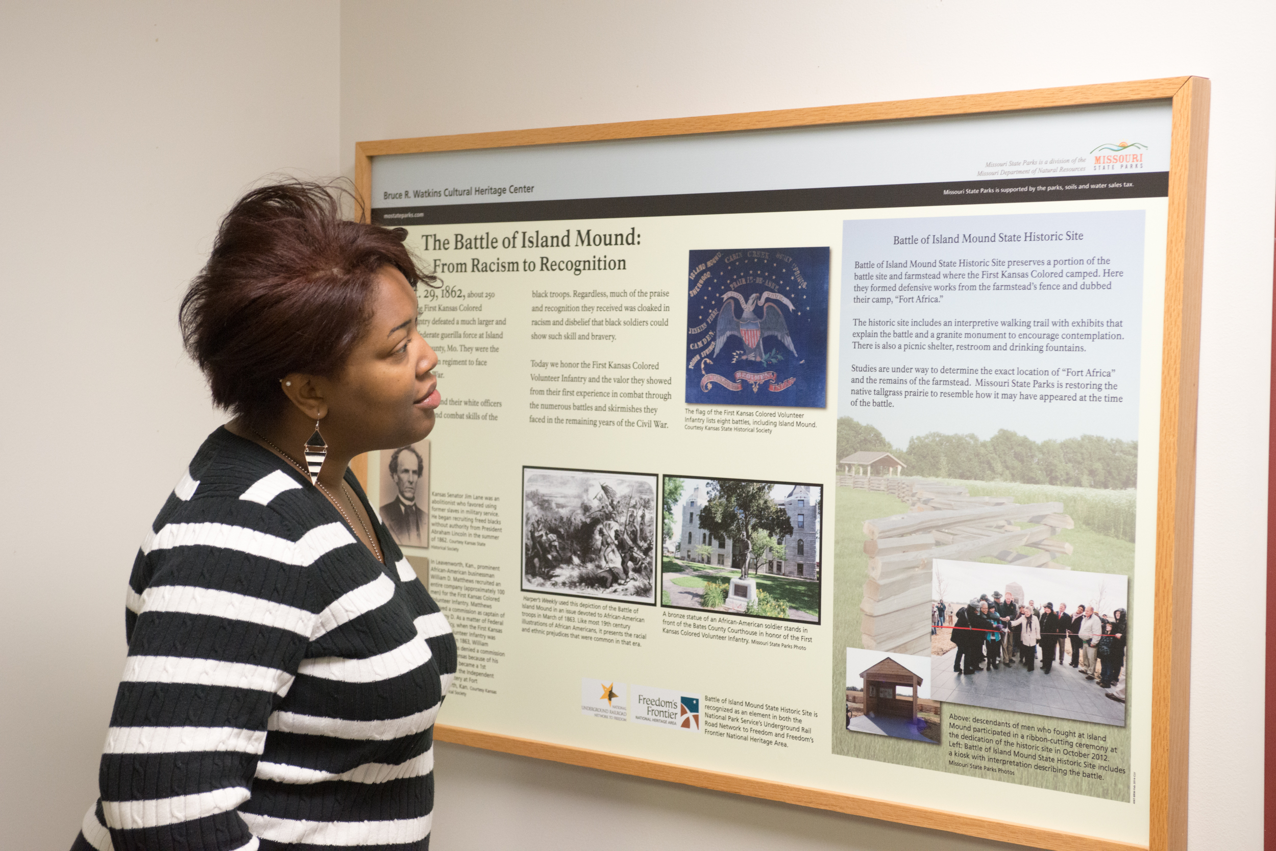 A woman looking at a historical display for the Battle of Island Mound