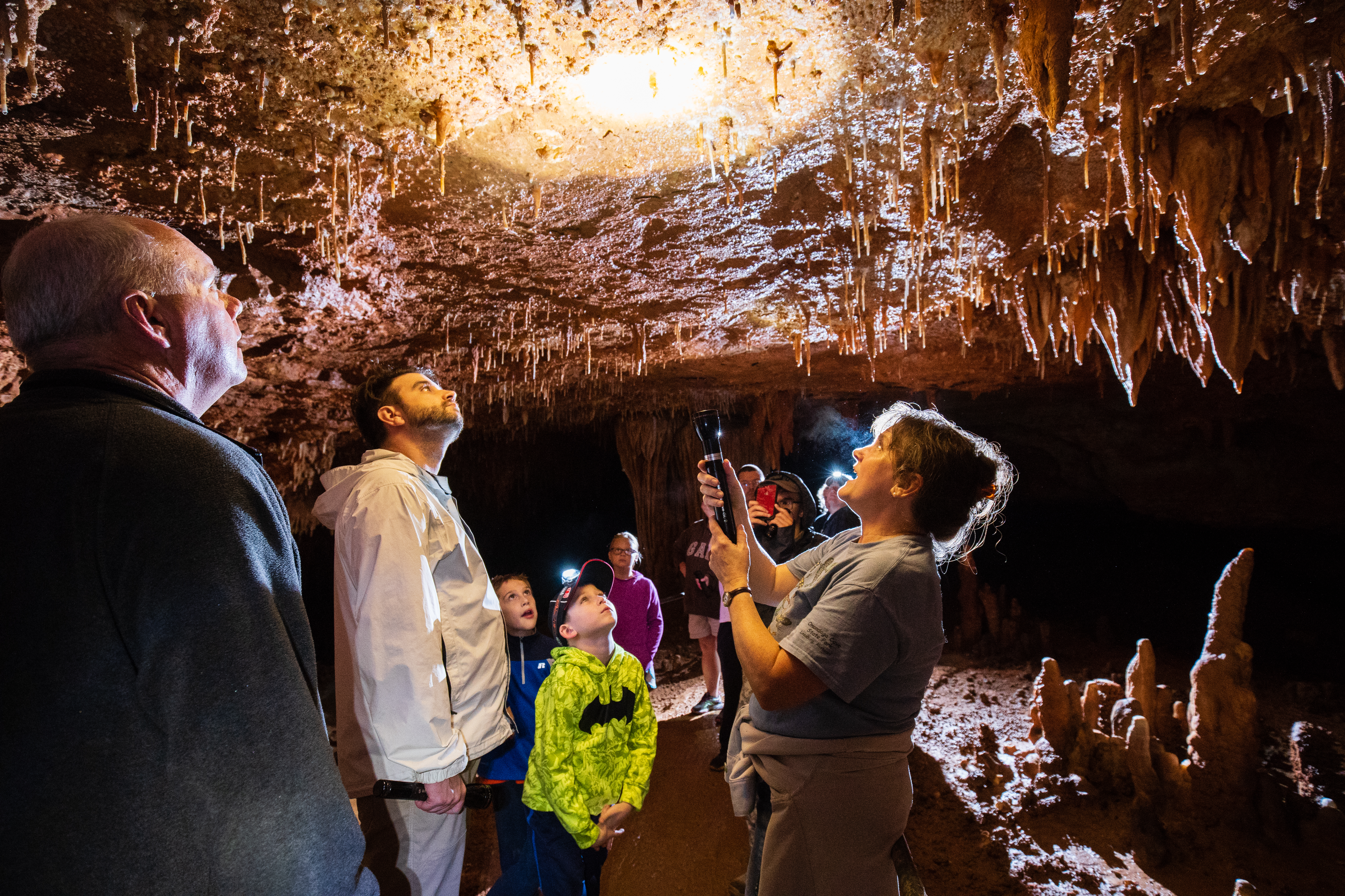 People gathered in a cave under a light