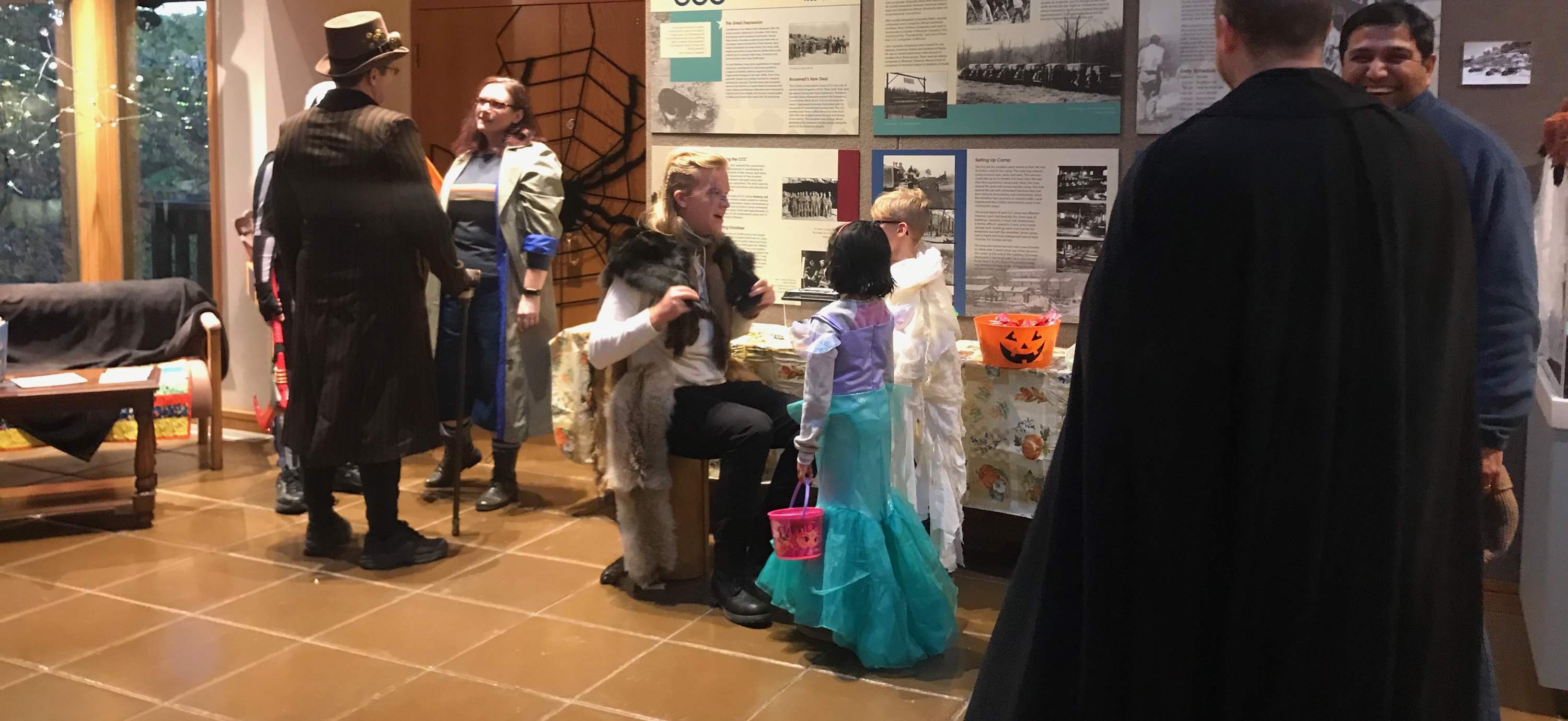 A park ranger talking to children dressed in costume at a halloween party