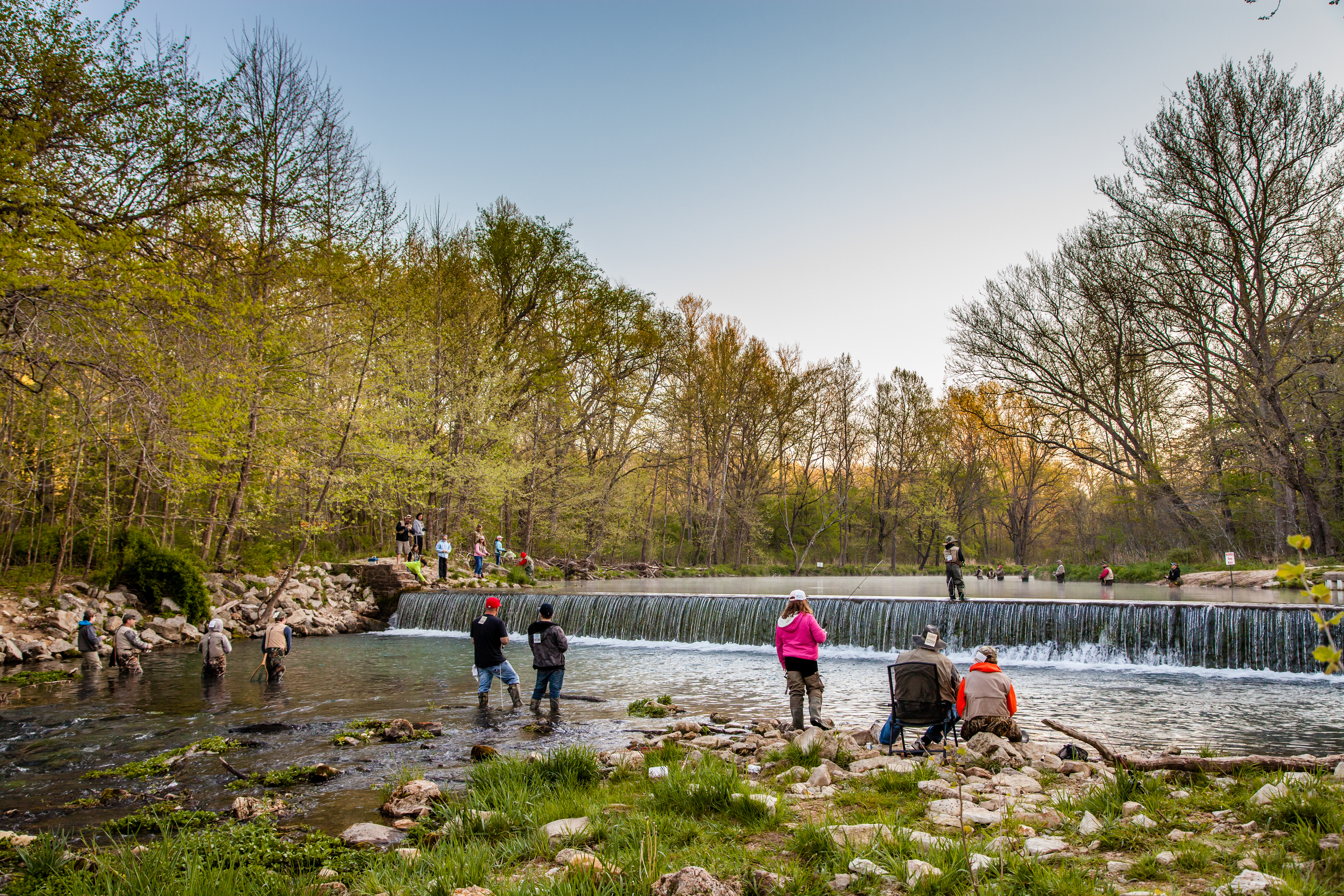 People fishing in a shallow river