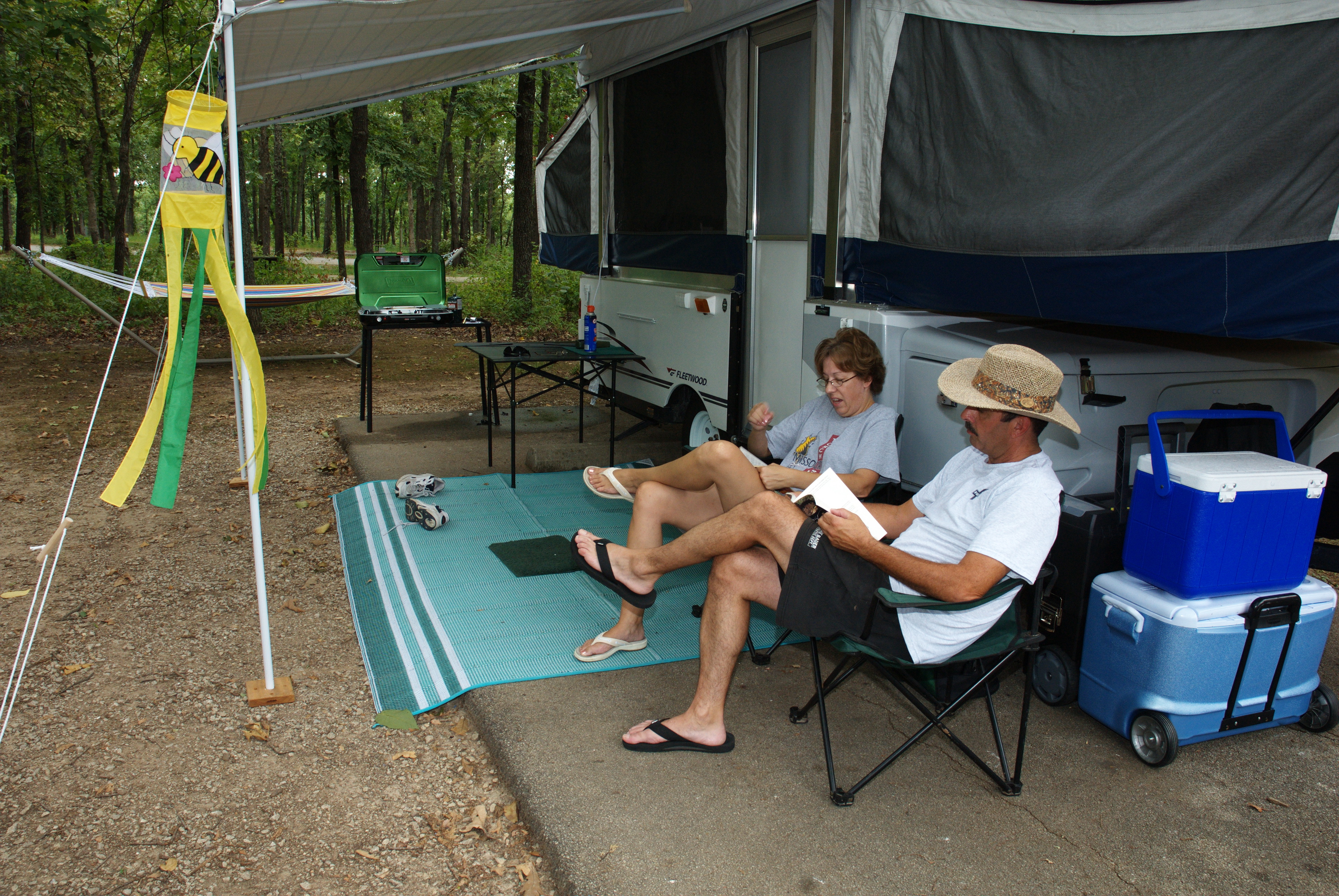 Two people sitting outside a camper