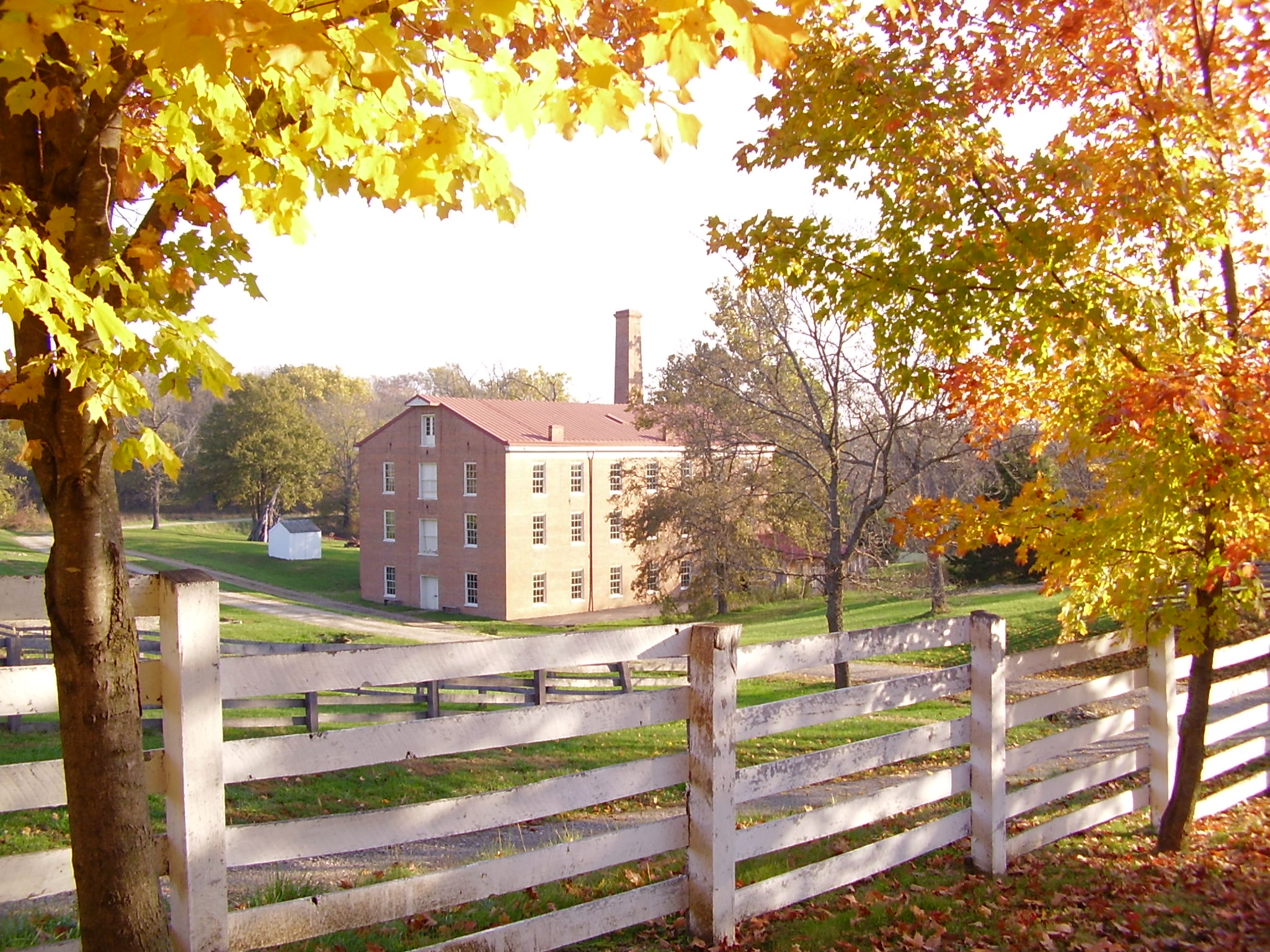 A brick building, as seen from behind a fence