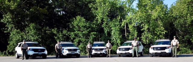 Rangers standing next to cars