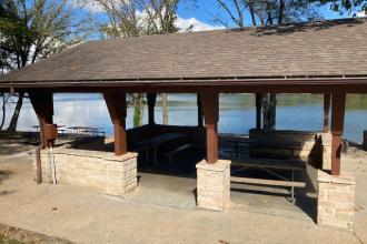 View of the picnic tables under the roof of the open shelter