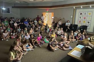 Children watching a video in the museum auditorium