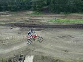 A person doing tricks on a dirt bike in a dirt field